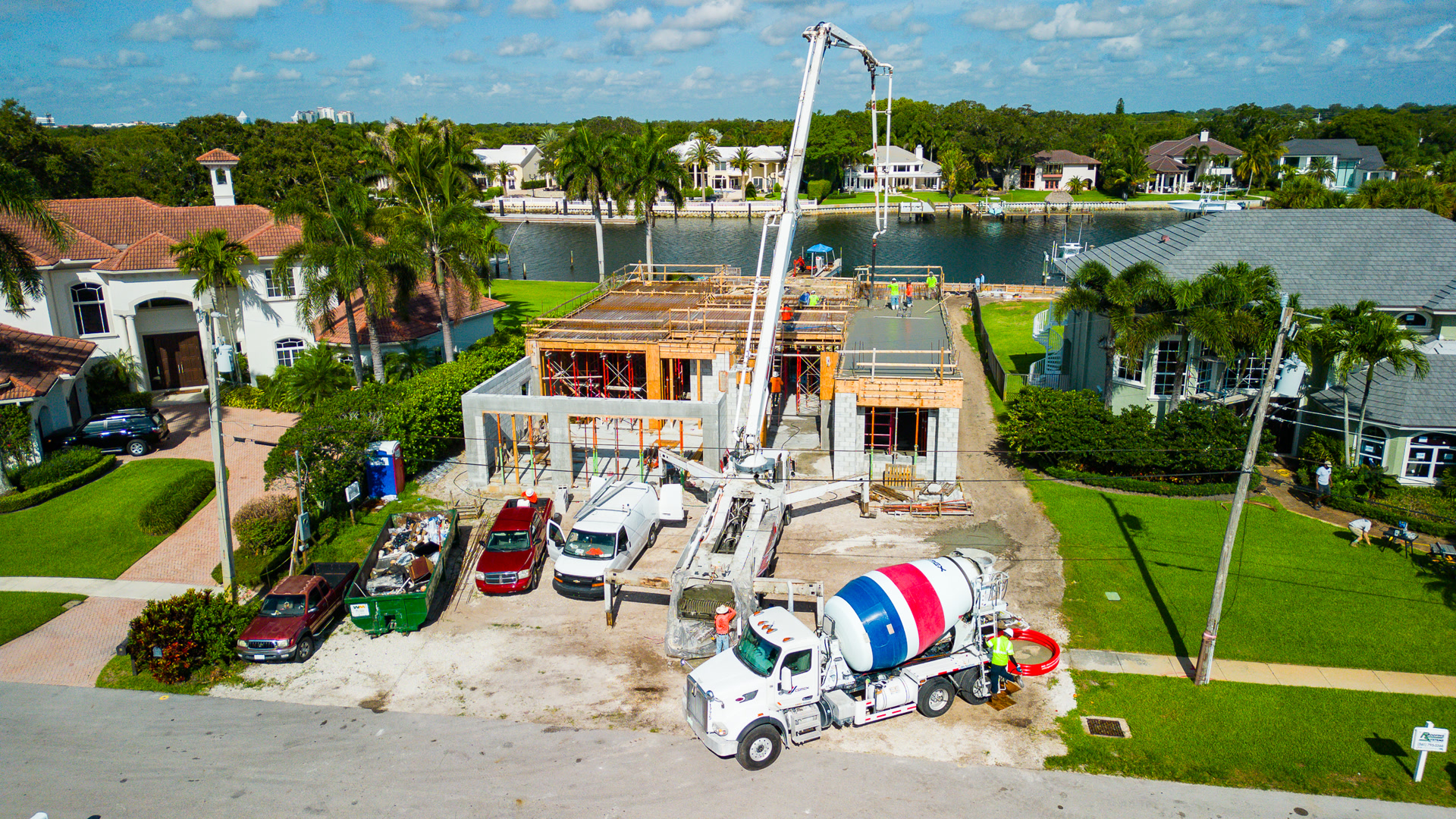 Concrete pour at a waterfront home site with pump truck