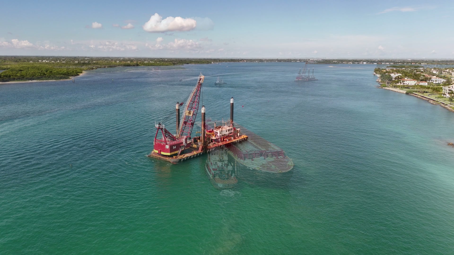 Tugboat guiding a barge through a South Florida inlet