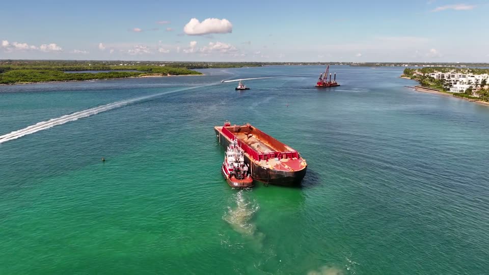 Video: tugboat guiding a barge through the inlet