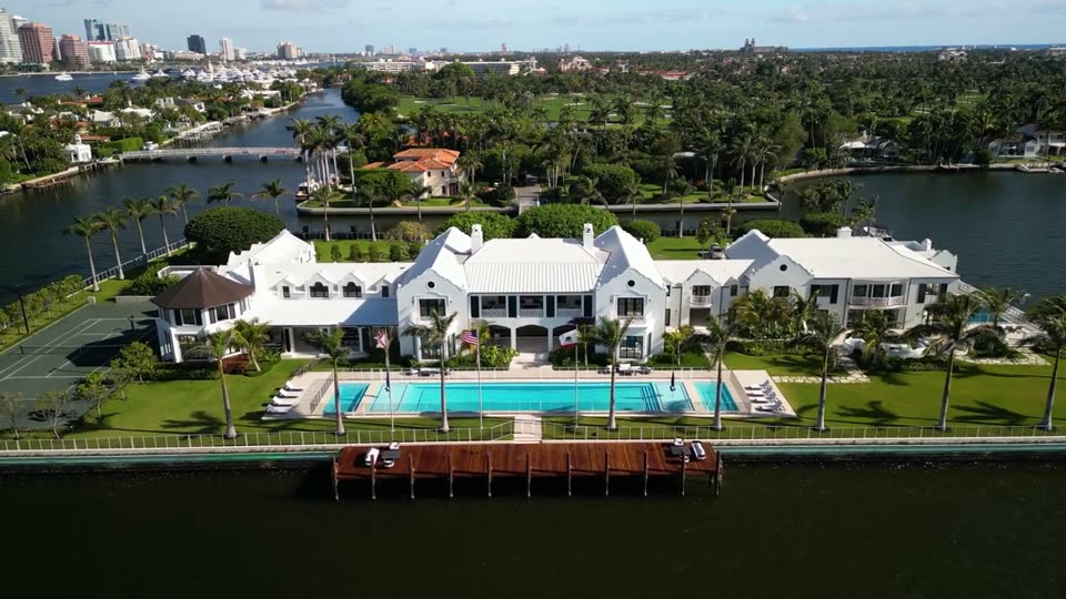 Video: aerial orbit of a waterfront mansion with pool and dock